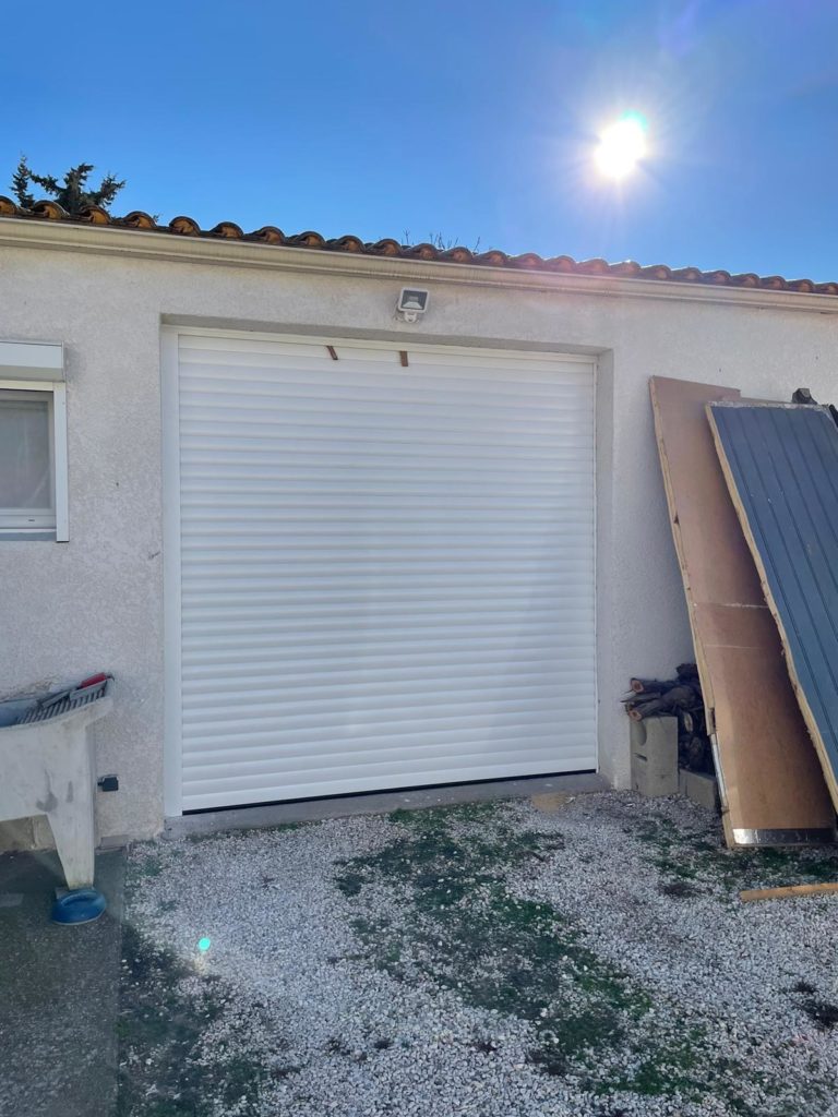 Porte de garage enroulable blanche sur une maison en construction