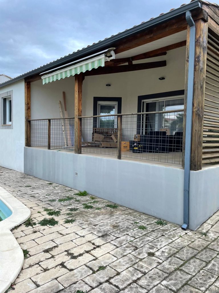 Store banne posé au-dessus d'une terrasse couverte