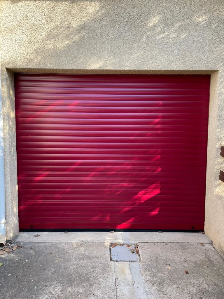 Porte de garage enroulable rouge posée par RenovPortes34