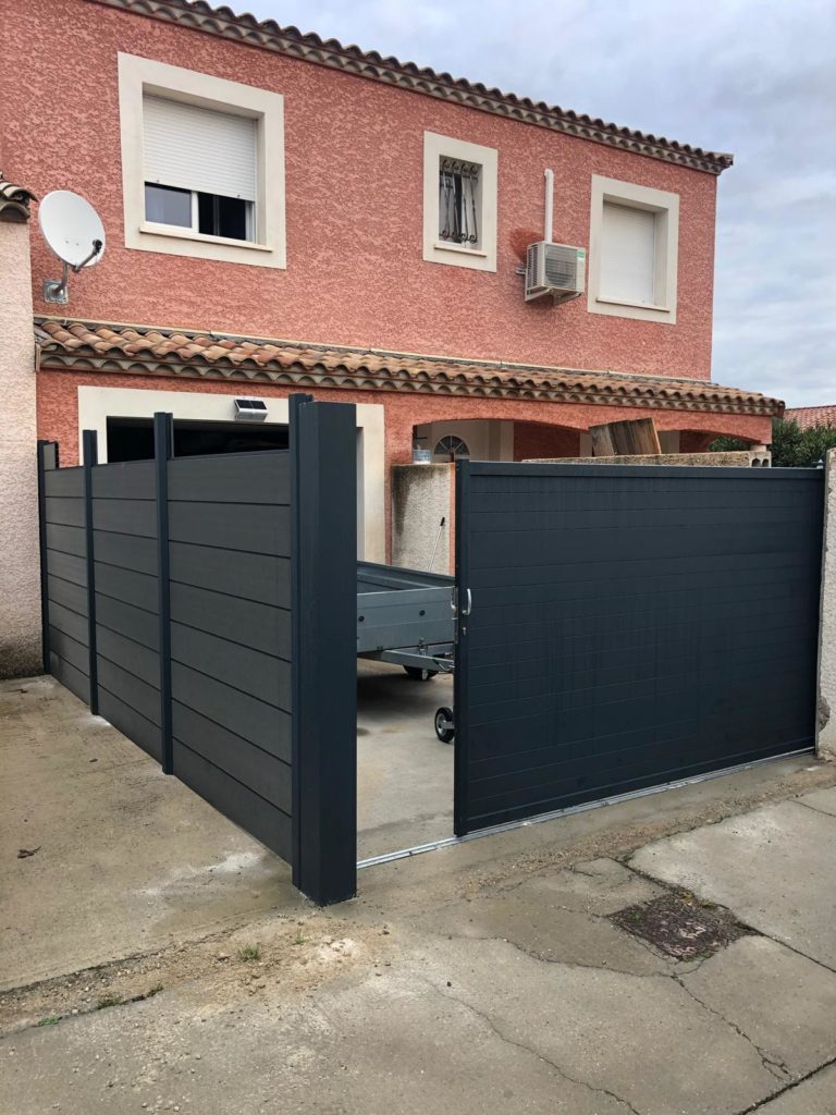 Clôture et portail gris posés devant une maison
