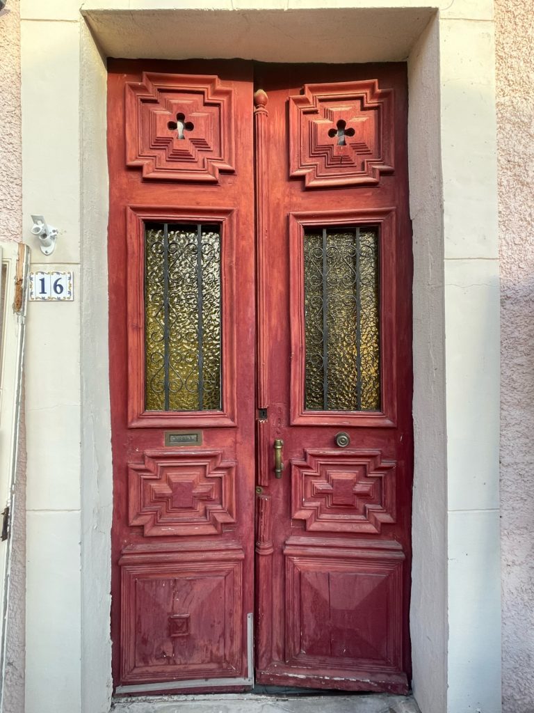 Avant : ancienne porte d'entrée double en bois rouge