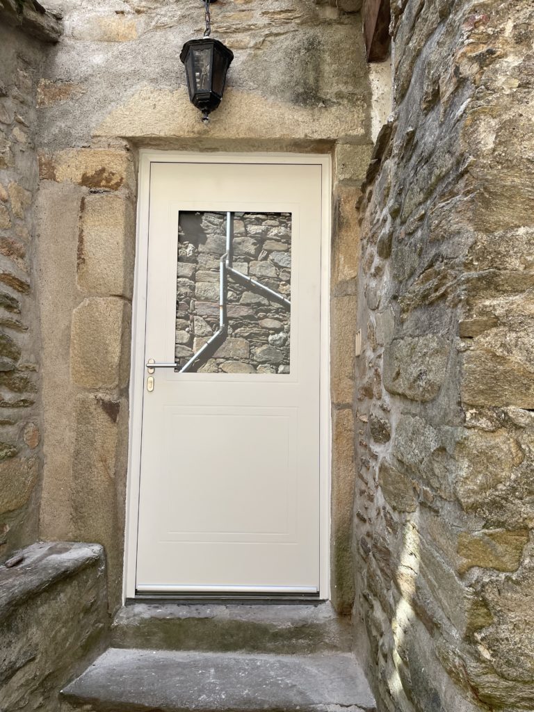 Après : porte d'entrée blanche vitrée dans le même passage en pierre
