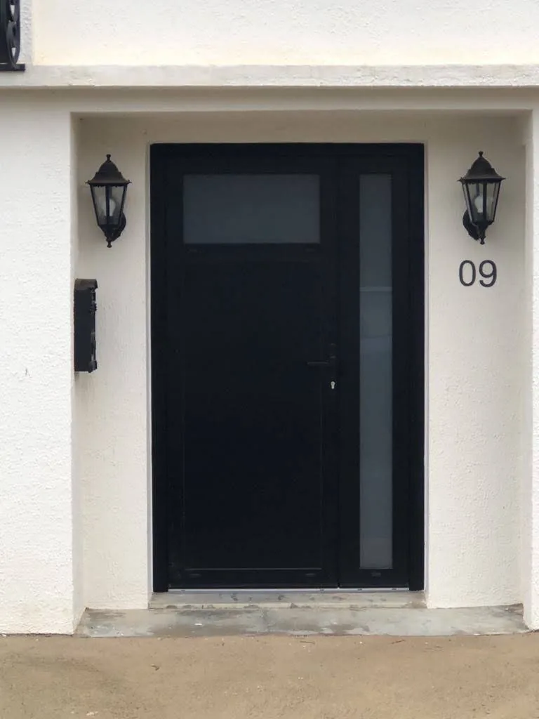 Porte d'entrée anthracite avec fixe latéral vitré posée par RenovPortes34, vue depuis la rue