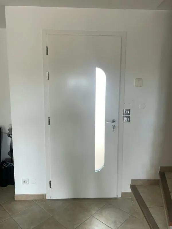 Porte d'entrée blanche à vitrage dépoli, vue depuis l'intérieur